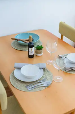a table with plates and glasses and a bottle of wine at Porto Cozy and Design Apartment in Porto Center in Porto