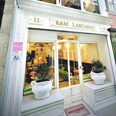 a store front with two potted plants in the window at DEUXMECS Porto in Porto