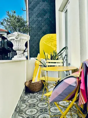 a balcony with yellow chairs and tables on a balcony at DEUXMECS Porto in Porto