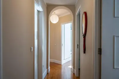 a hallway with an archway and a hallway with a door at Large and Charming Apartment Downtown in Porto
