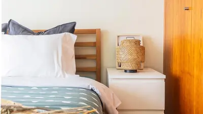 a bedroom with a bed and a lamp on a night stand at Apartamento com varanda e garagem in Porto