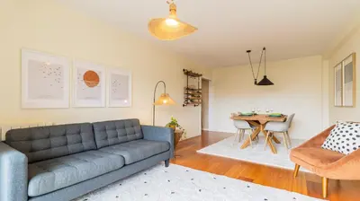 a living room with a couch and a table at Apartamento com varanda e garagem in Porto