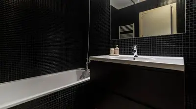 a bathroom with a sink and a mirror and a tub at Apartamento com varanda e garagem in Porto