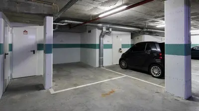 a parking garage with a car parked in it at Apartamento com varanda e garagem in Porto