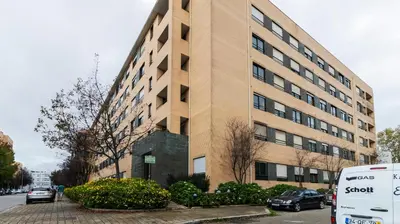 a large building with cars parked in front of it at Apartamento com varanda e garagem in Porto