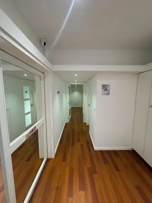 an empty hallway with wood floors and white walls at Dormitório Aliados in Porto