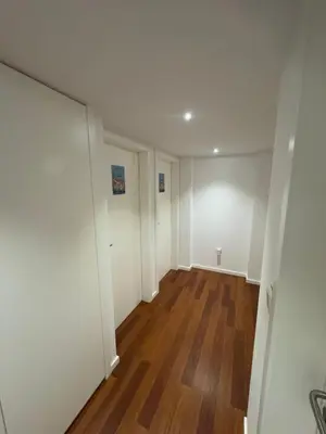 an empty room with white walls and wood floors at Dormitório Aliados in Porto
