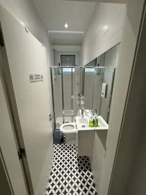 a small bathroom with a sink and a toilet at Dormitório Aliados in Porto