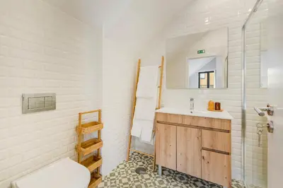 a bathroom with a sink and a toilet and a mirror at GuestReady - Alegria Guesthouse in Porto