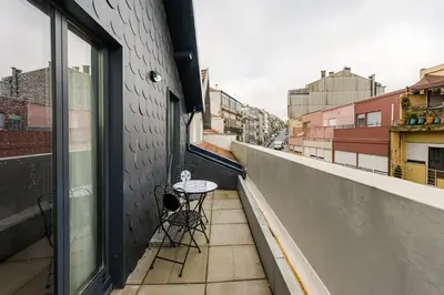 a balcony with a table and chairs on a building at GuestReady - Alegria Guesthouse in Porto