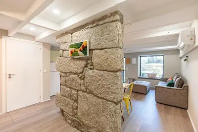 a large stone wall in a room with a living room at GuestReady - Alegria Guesthouse in Porto