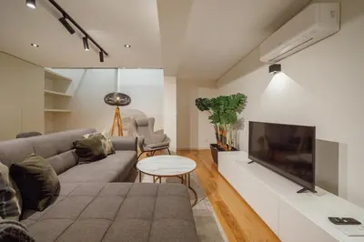 a living room with a couch and a flat screen tv at 24 Agosto Amazing Triplex by Vacationy in Porto