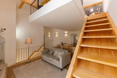 a living room with stairs leading up to a loft at D&S - Antas House in Porto