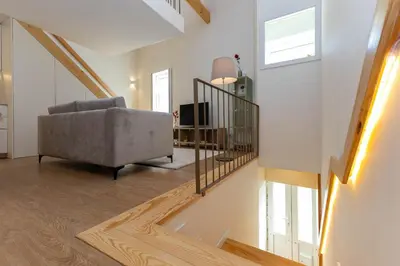 a living room with a chair and a staircase at D&S - Antas House in Porto