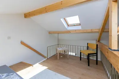 a room with a table and two chairs in a attic at D&S - Antas House in Porto