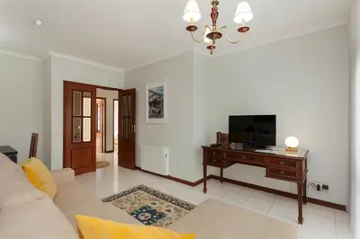 a living room with a couch and a television at Guilhermina's Place in Vila Nova de Gaia