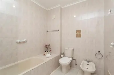 a white bathroom with a toilet and a bath tub at Guilhermina's Place in Vila Nova de Gaia