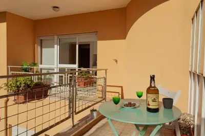 a table with a bottle of wine on a balcony at Guilhermina's Place in Vila Nova de Gaia