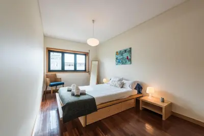 a bedroom with a bed and a chair and a window at GuestReady - Even Flow Flat in Porto