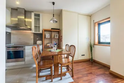 a kitchen with a wooden table and chairs at GuestReady - Even Flow Flat in Porto
