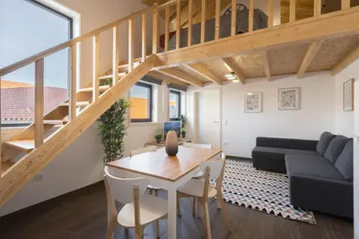 a living room with a wooden table and a loft at Host Wise - Stylish Duplex House - Terrace & River View in Vila Nova de Gaia