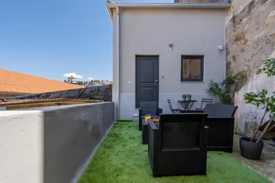 a patio with grass and chairs on a building at Host Wise - Stylish Duplex House - Terrace & River View in Vila Nova de Gaia