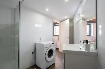 a bathroom with a washing machine and a sink at Host Wise - Stylish Duplex House - Terrace & River View in Vila Nova de Gaia