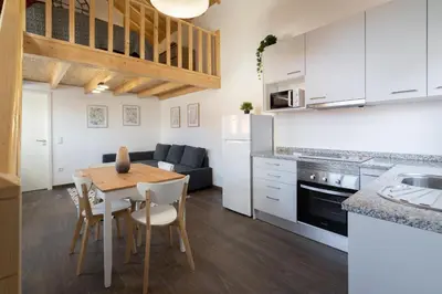 a kitchen and living room with a table and a couch at Host Wise - Stylish Duplex House - Terrace & River View in Vila Nova de Gaia