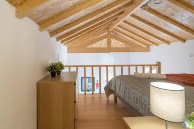 a bedroom with a bed and a wooden ceiling at Host Wise - Stylish Duplex House - Terrace & River View in Vila Nova de Gaia