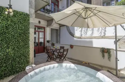 a jacuzzi tub with an umbrella on a patio at Host Wise - Spacious Bright Flat - Terrace in Porto