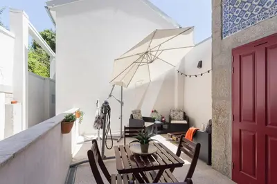 a patio with a wooden table and an umbrella at Host Wise - Spacious Bright Flat - Terrace in Porto