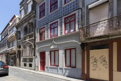 a building with red and blue windows on a street at Host Wise - Spacious Bright Flat - Terrace in Porto