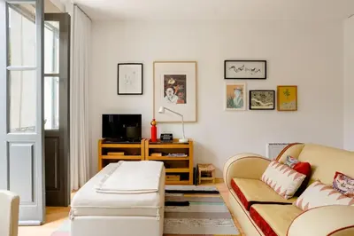 a living room with a couch and a tv at Sunny Priorado Vintage studio with balcony in Porto