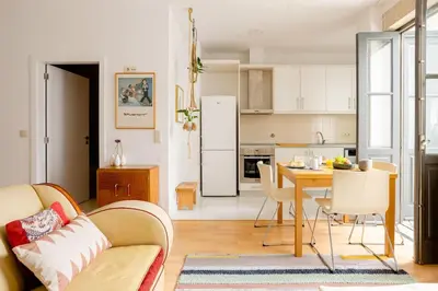a kitchen and dining room with a table and chairs at Sunny Priorado Vintage studio with balcony in Porto