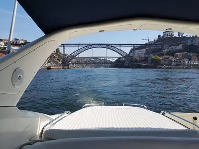 a view from the back of a boat on a river with a bridge at Groove-Wood Loft in Vila Nova de Gaia