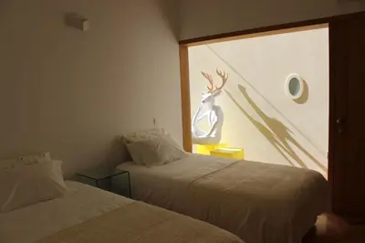 two beds in a room with a deer on the window at Groove-Wood Loft in Vila Nova de Gaia