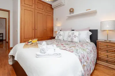a bedroom with a bed with a tray of food on it at Host Wise - Rustic Bright Flat - City Centre in Porto