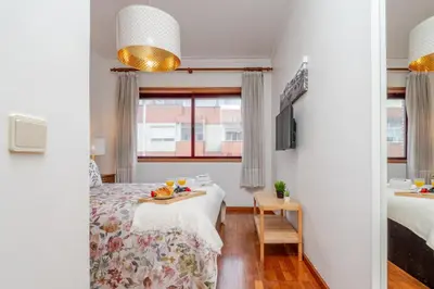 a bedroom with a bed and a table with food on it at Host Wise - Rustic Bright Flat - City Centre in Porto