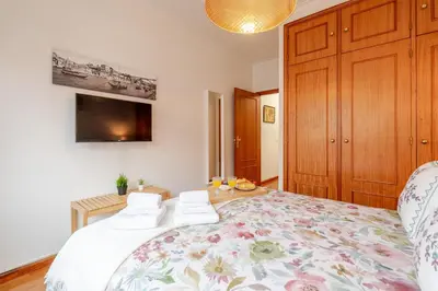a bedroom with a large bed and a tv at Host Wise - Rustic Bright Flat - City Centre in Porto