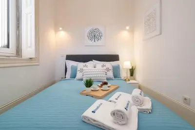a bedroom with a blue bed with towels on it at Host Wise - Modern Comfy Flat in Porto