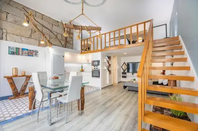 a dining room and living room with a glass table and white chairs at Host Wise - Deluxe Spacious Flats w Mezzanine in Porto