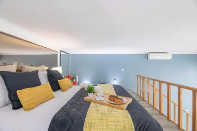 a bedroom with a large bed with a tray on it at Host Wise - Deluxe Spacious Flats w Mezzanine in Porto