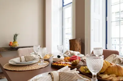 a dining room table with food and wine glasses at Host Wise - Deluxe Spacious Flats w Mezzanine in Porto