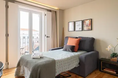 a small bedroom with a bed and a window at Host Wise - Modern Design Duplex w Balcony in Porto