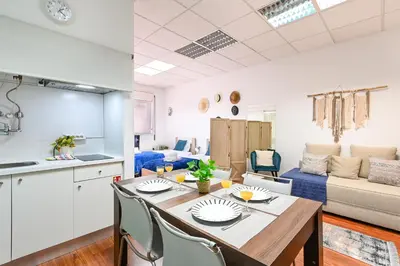 a kitchen and a living room with a table and chairs at Coliseu Oporto Center in Porto