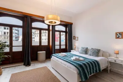 a bedroom with a bed and a large window at Poveiros Studio OPorto City Center in Porto