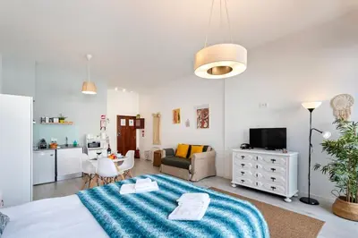 a bedroom with a large bed with a blue blanket at Poveiros Studio OPorto City Center in Porto