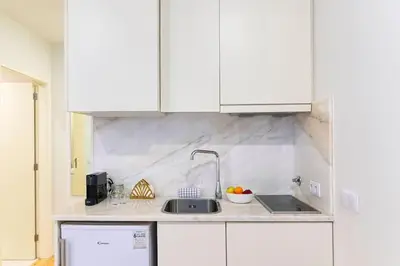 a kitchen with white cabinets and a sink at Santa Catarina Oporto City Center in Porto