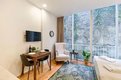 a hotel room with a bed and a desk and a table at Santa Catarina Oporto City Center in Porto