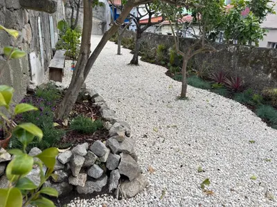 a garden with rocks and trees and a wall at Bright apartment with garden in Porto